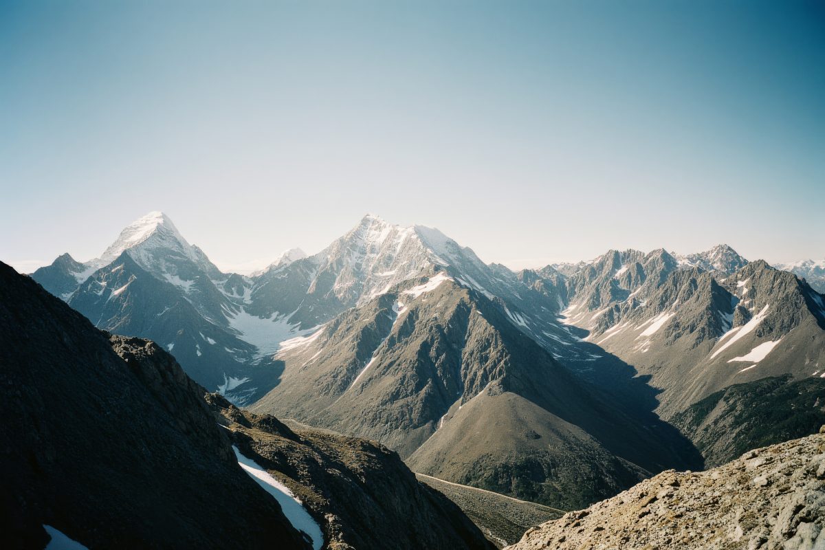 Panoramic View of Snow-Capped Rocky Mountain Peaks Under a Clear Blue Sky